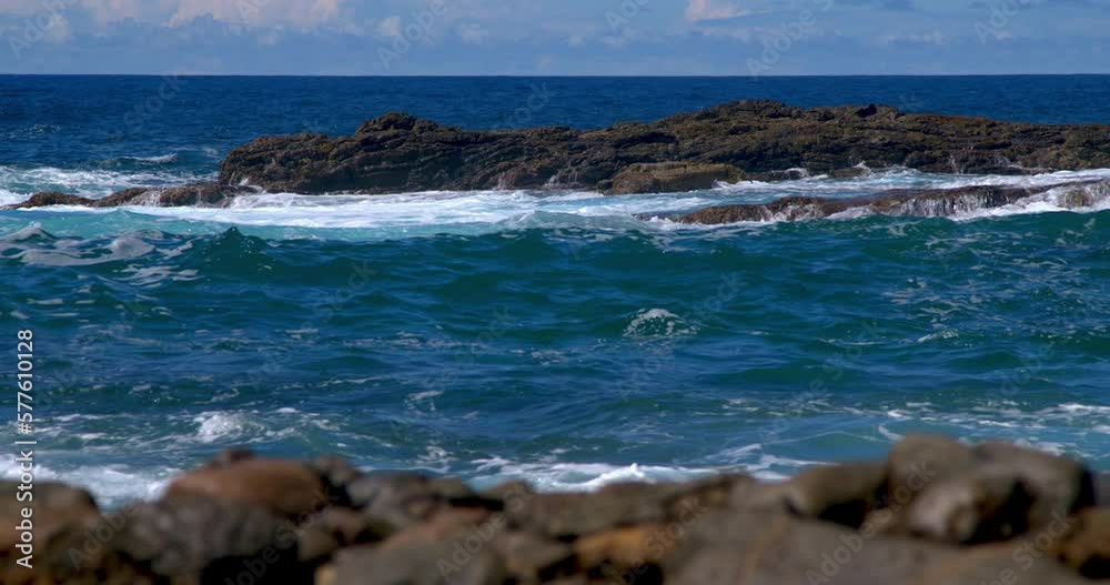 Powerful waves are crashing and foaming against black volcanic rocks on the coast of Fuerteventura island. Travel and vacation concept. Powerful waves are crashing and foaming against black volcanic rocks on the coast of Fuerteventura island. Travel and vacation concept.