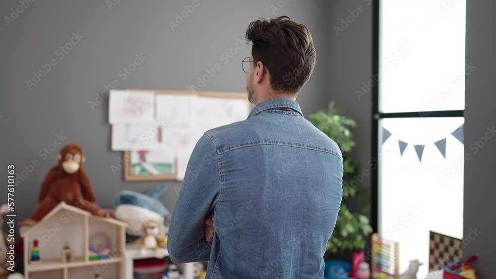 Young hispanic man preschool teacher smiling confident standing with arms crossed gesture at kindergarten Young hispanic man preschool teacher smiling confident standing with arms crossed gesture at kindergarten