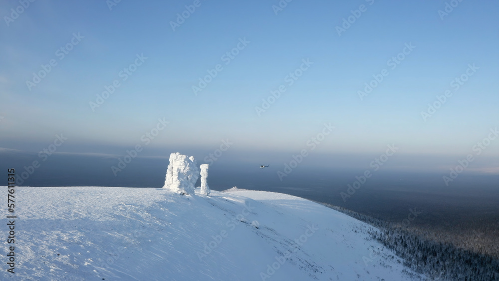 Aerial winter view of giants of the Manpupuner Plateau, Komi Republic. Clip. Helicopter flying above snow covered hills.
