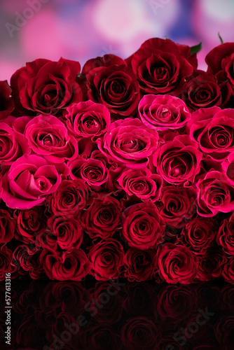 Women   s day concept. Bouquet of red roses on shining table and blue bokeh  background.