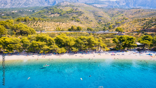 Take in the breathtaking aerial view of Makarska Riviera in Croatia, revealing a picturesque rocky beach and the vibrant turquoise water.