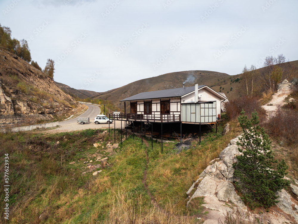 Wooden roadside cafe on a mountain highway. Smoke from a chimney on the roof of a roadside restaurant. Karachay-Cherkessia. Wooden roadside cafe on a mountain highway. Smoke from a chimney on the roof of a roadside restaurant. Karachay-Cherkessia.