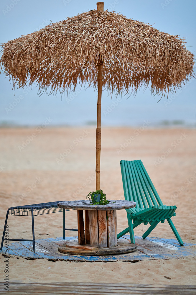 green chair and palm tree on the sandy beach of the baltic sea in gdansk, poland