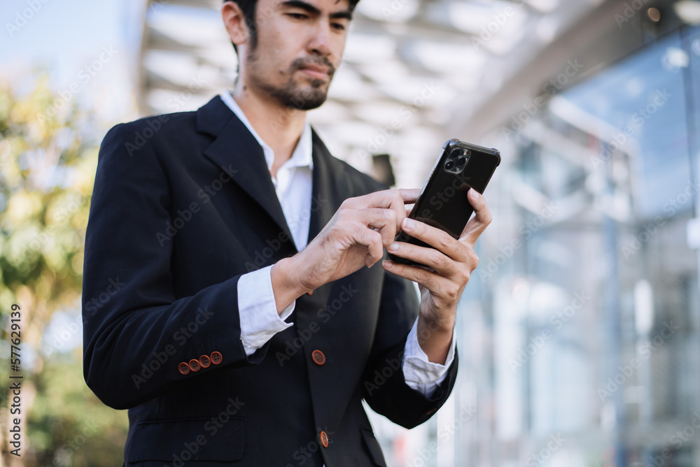 Businessman using a digital tablet outside an office building.. Businessman using a digital tablet outside an office building..