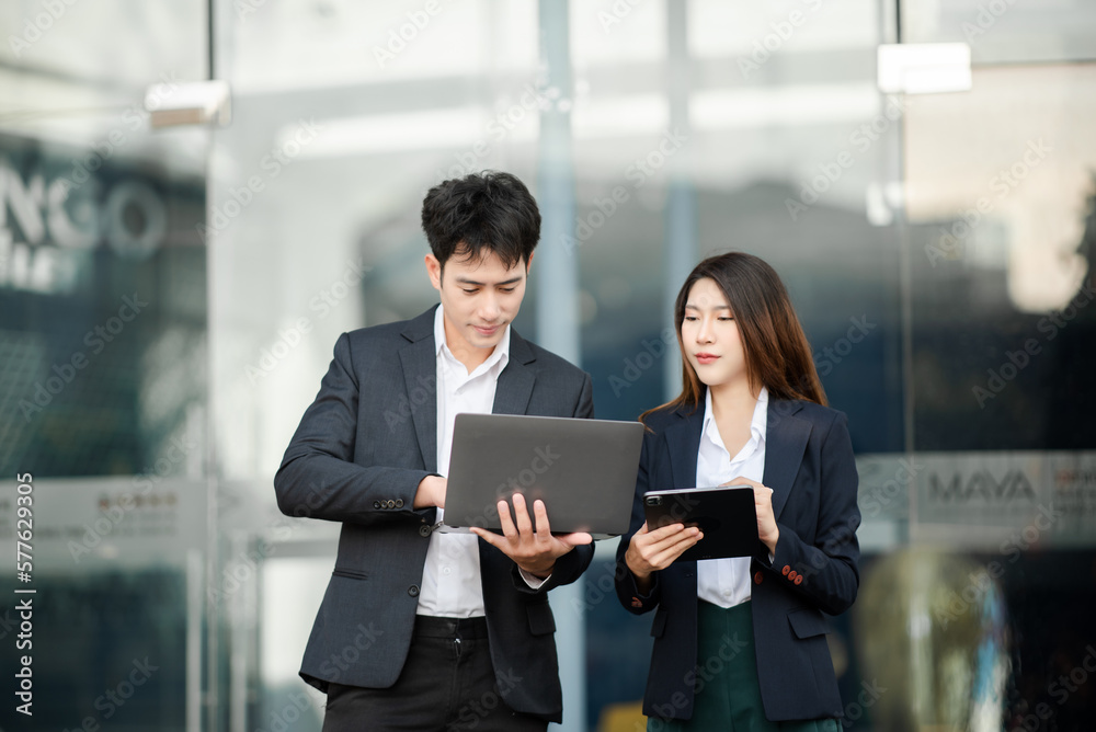 Kind leader executive manager share and discuss business solutions plan ideas on tablet with Asian female marketing manager in modern office.. Kind leader executive manager share and discuss business solutions plan ideas on tablet with Asian female marketing manager in modern office..