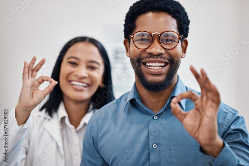 Perfect, optometry and portrait of a black man and optician with glasses, eyecare and choice of eyewear. Okay, happy and patient with a decision on eyeglasses with an optometrist and hand gesture