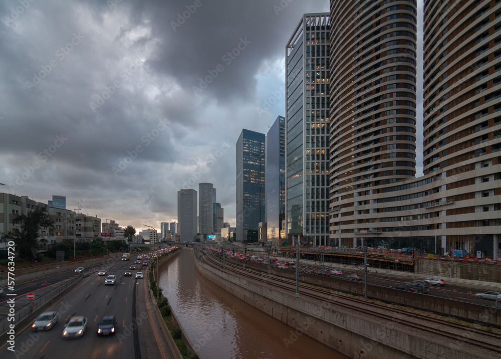 Cloudy gloomy Tel Aviv city before the sunset. Modern glass skyscrapers and automobile Ayalon highway Cloudy gloomy Tel Aviv city before the sunset. Modern glass skyscrapers and automobile Ayalon highway