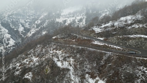 Zambla pass is a mountain pass in  Orobie Pre-Alps Selvino,  province of Bergamo, which connects the Serina and Parina valleys, Curved mountain road with hairpin bends and cars in a winter snowy  photo