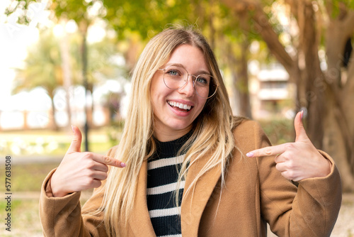 Young pretty blonde woman at outdoors proud and self-satisfied