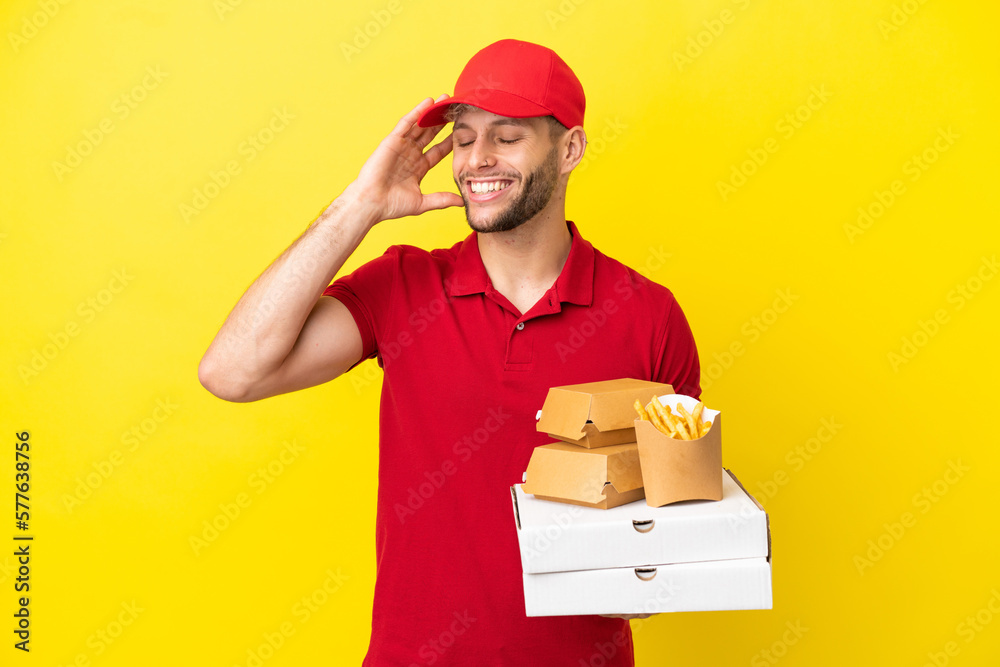 pizza delivery man picking up pizza boxes and burgers over isolated background smiling a lot pizza delivery man picking up pizza boxes and burgers over isolated background smiling a lot