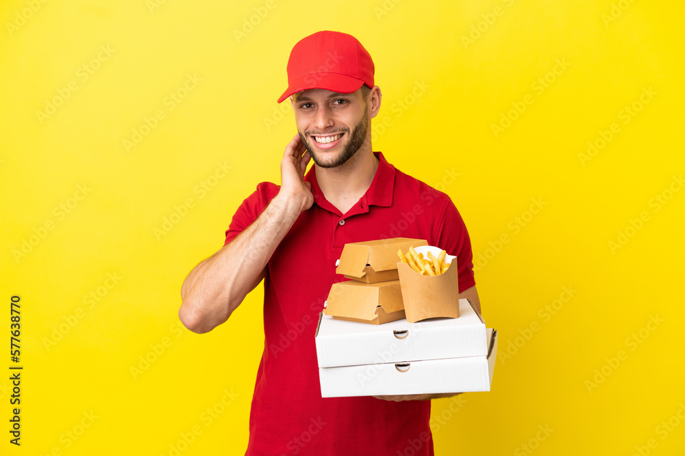 pizza delivery man picking up pizza boxes and burgers over isolated background laughing pizza delivery man picking up pizza boxes and burgers over isolated background laughing