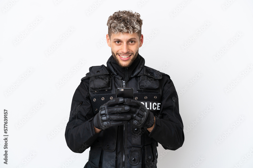 SWAT caucasian man isolated on white background sending a message with the mobile SWAT caucasian man isolated on white background sending a message with the mobile
