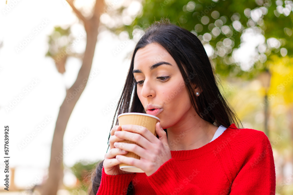 Young woman holding a take away coffee at outdoors Young woman holding a take away coffee at outdoors