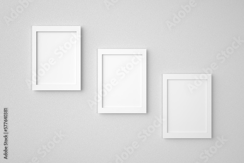Three blank or empty rectangle picture frames hanging on white wall. Mockup background image. 3D rendering.