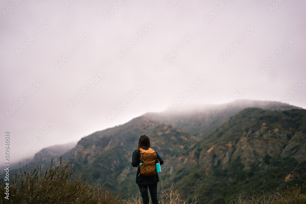 woman hiker enjoy the view on top of mountain at foggy day