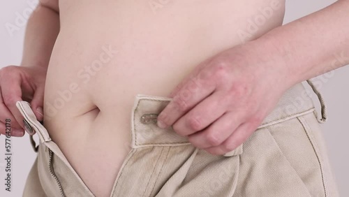 woman belly in jeans. woman with big belly trying button up jeans. Concept of excessive weight, obese female, dieting and overweight problems.