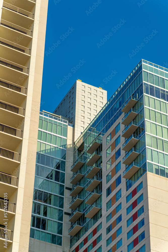 Buildings and skyscrapers in downtown san antonio texas with blue windows and beige exteriors and facades with blue sky
