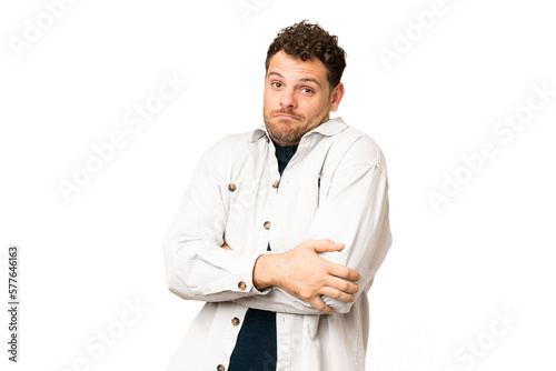 Brazilian man over isolated chroma key background making doubts gesture while lifting the shoulders