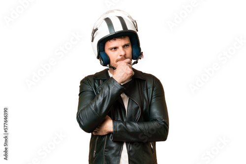 Brazilian man with a motorcycle helmet over isolated chroma key background having doubts and thinking