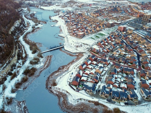 Aerial drone. Ebbsfleet garden city in Kent, covered in snow in December 2022. Aerial view of new developments and frozen lake alongside the A2 motorway. photo