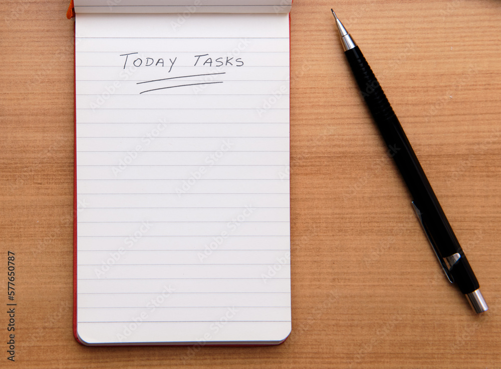 Today Tasks text hand written with a pencil on a notepad to encourage daily planning and organization. View from top Today Tasks text hand written with a pencil on a notepad to encourage daily planning and organization. View from top