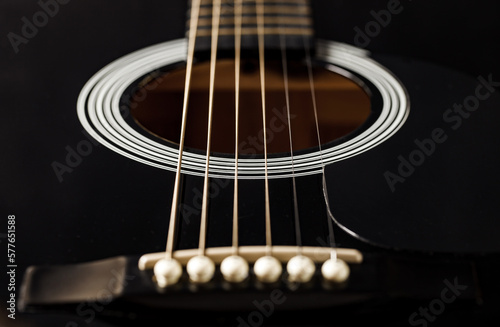 Guitar black, string instrument, six strings stretched, polished smooth soundboard, lower threshold, close-up macro, selective focus