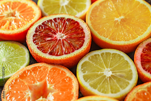 Citrus fruits cut in half  oranges  tangerines  yellow lemons  green limes  top view close-up  selective focus