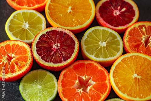 Citrus fruits cut in half, oranges, tangerines, yellow lemons, green limes, close-up selective focus
