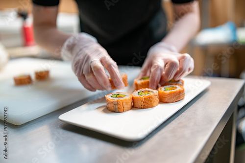 professional chef's hands making sushi and rolls in a restaurant kitchen
