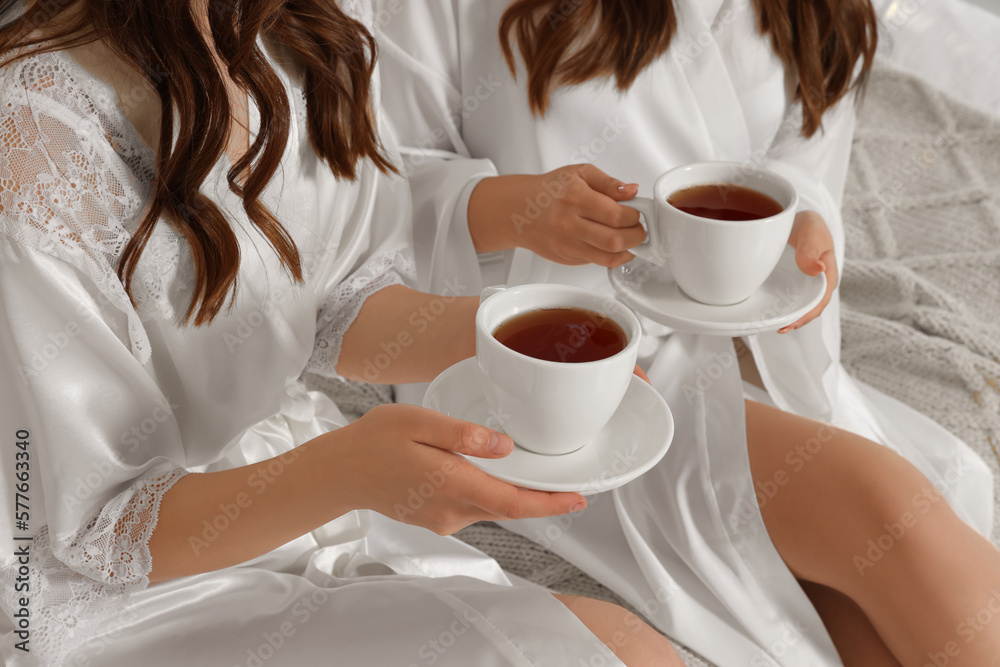 Bride and her bridesmaid with cups of tea at home, closeup. Wedding day Bride and her bridesmaid with cups of tea at home, closeup. Wedding day