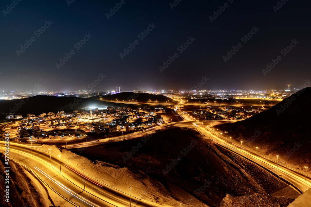 Mesmerizing night view of winding roads and trailing lights from Amarat Heights, Al-Jabal Street - Amerat to Bausher Mountain Road - in Muscat, the Sultanate of Oman.