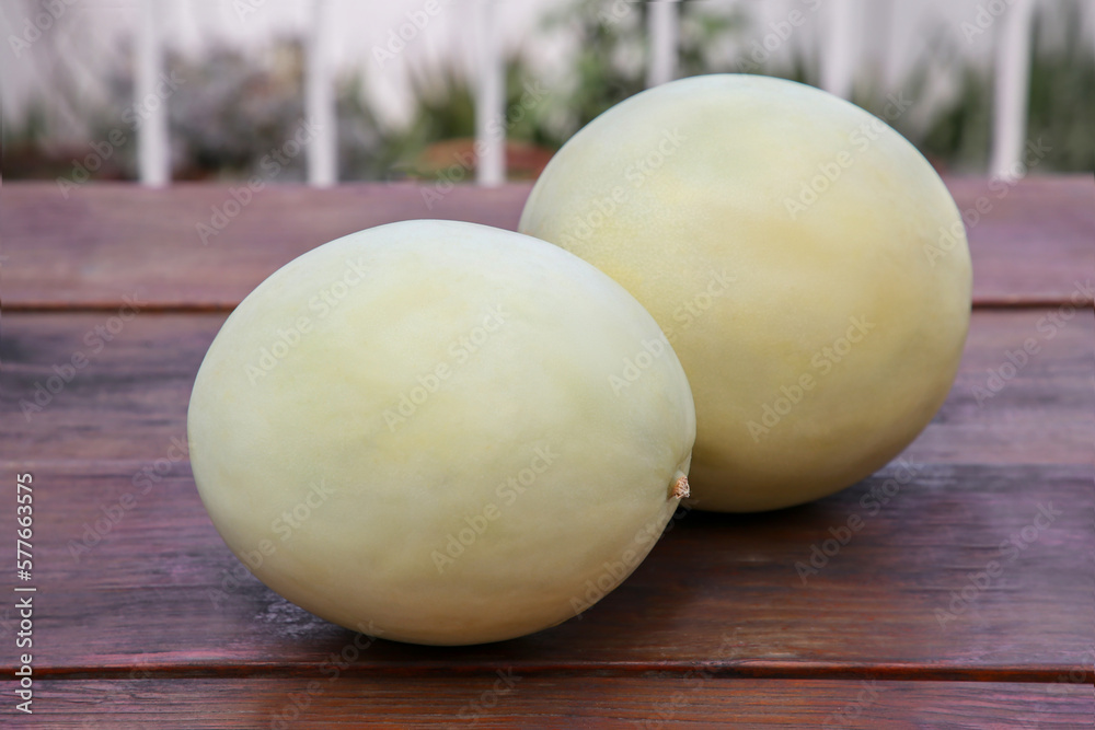 Whole fresh ripe melons on wooden table outdoors Whole fresh ripe melons on wooden table outdoors