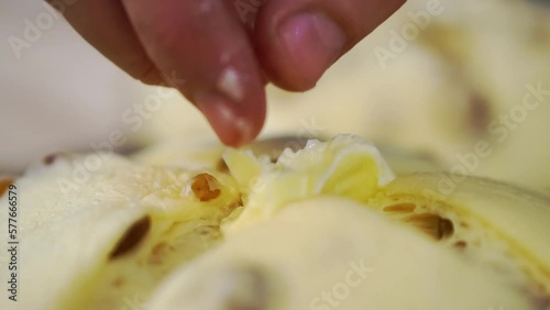 Baker hand puts piece of butter inside crossed cut in dough