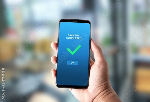 payment completed notification in a mobile phone screen on bright blurred background