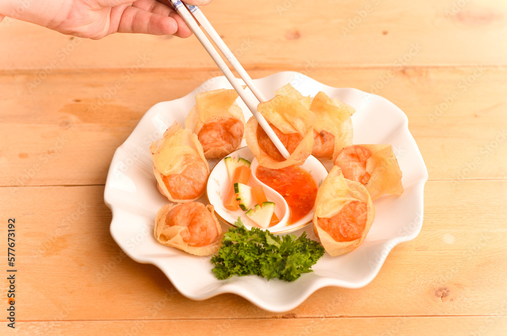 Chinese dumpling recipe called fried wontons eated by onion sauce isolated on wood table
Chinese dumpling recipe called fried wontons eated by onion sauce isolated on wood table