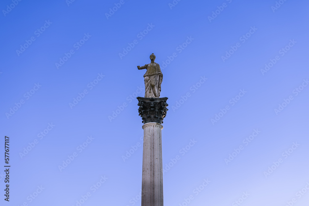 Statue of Minerva on the Colonna di Minerva and Galleria degli Antichi against the blue sky. Sabbioneta, Lombardy, Italy