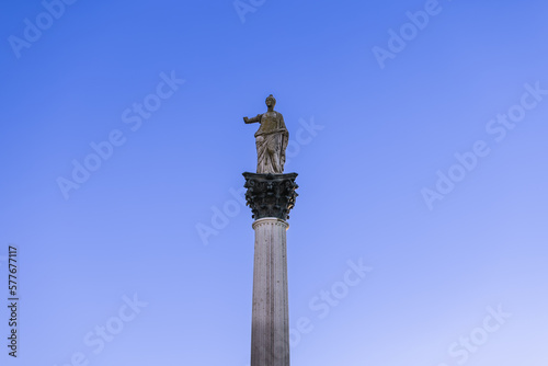 Statue of Minerva on the Colonna di Minerva and Galleria degli Antichi against the blue sky. Sabbioneta, Lombardy, Italy