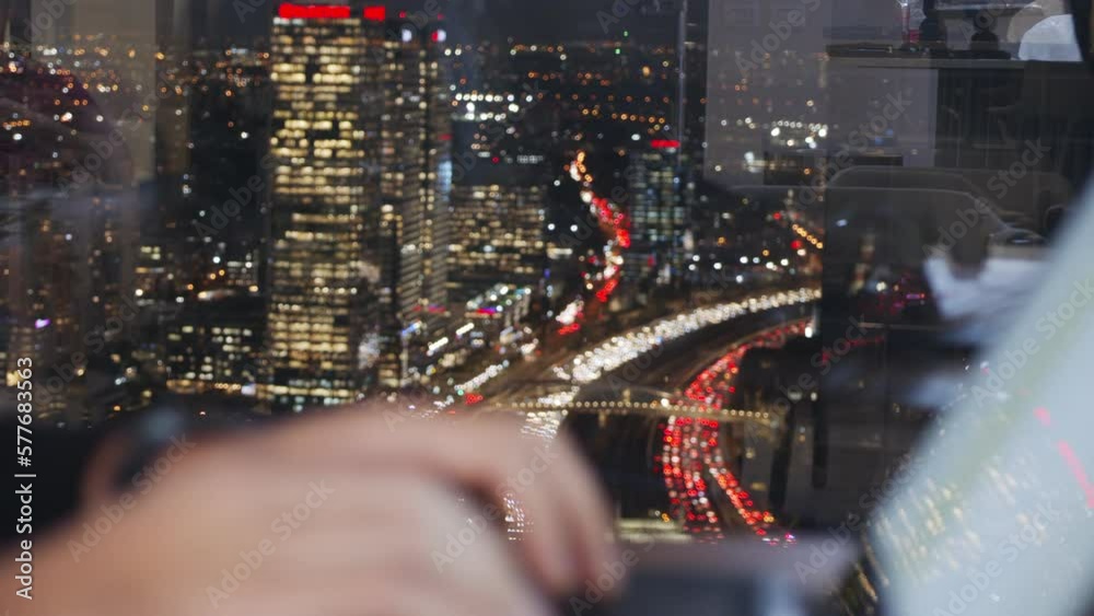 Man hands typing on a laptop computer keyboard - change focus to large city lights in the background. Man hands typing on a laptop computer keyboard - change focus to large city lights in the background.
