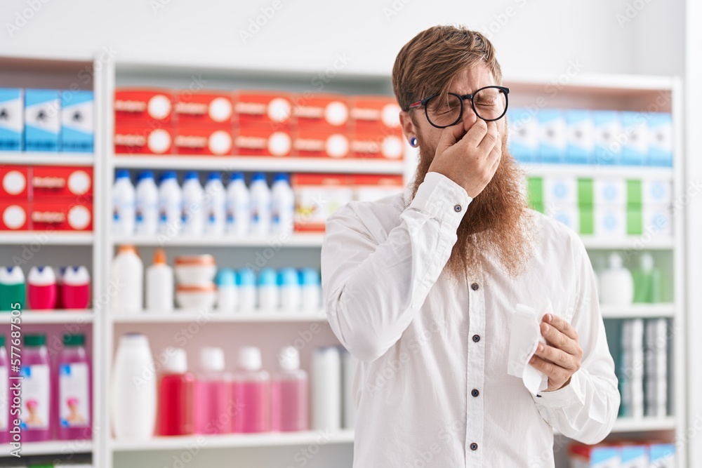 Young redhead man customer using nakpin at pharmacy Young redhead man customer using nakpin at pharmacy