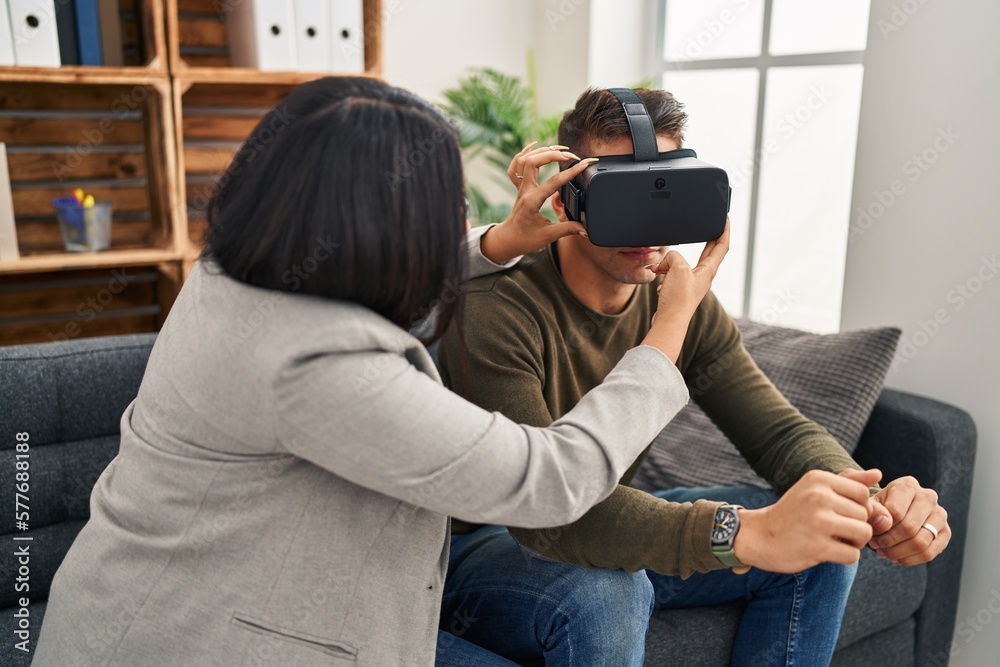 Man and woman having virtual reality psychology session at clinic