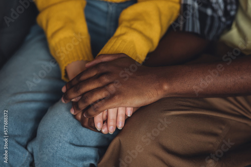 Mixed ethnicity couple, international family, African American man and caucasian woman holding hands. Love, trust, support of people of different skin colour, race, culture. Session at psycologist