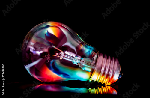 A light bulb, isolated on a black background, with abstract reflections on it.