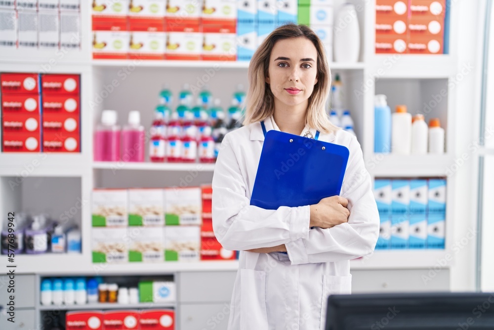 Young woman pharmacist holding checklist at pharmacy