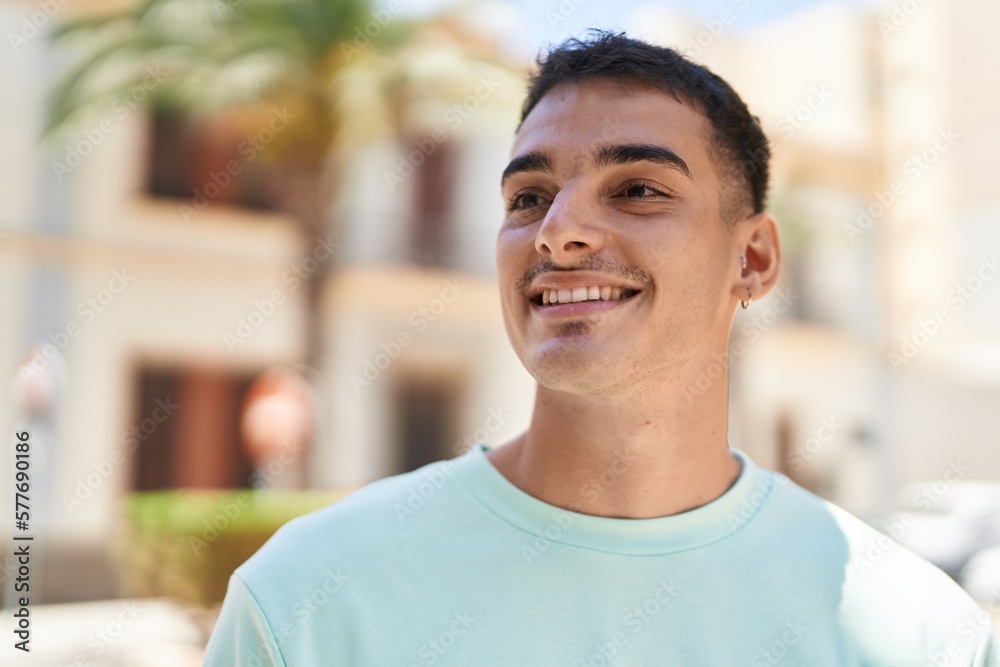 Young hispanic man smiling confident looking to the side at street Young hispanic man smiling confident looking to the side at street