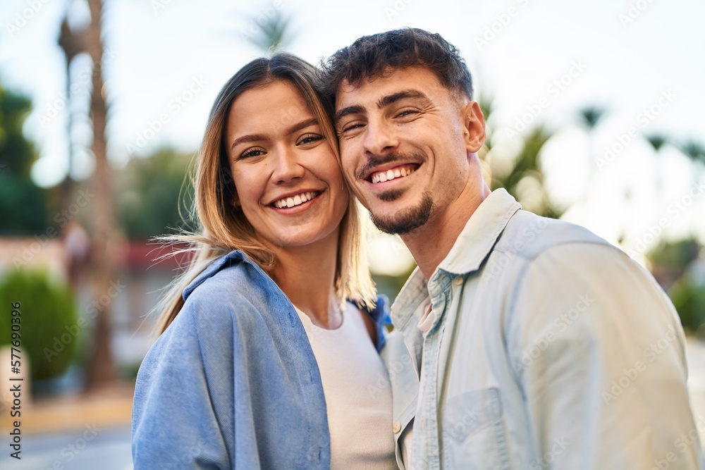 Young man and woman couple hugging each other standing at street Young man and woman couple hugging each other standing at street