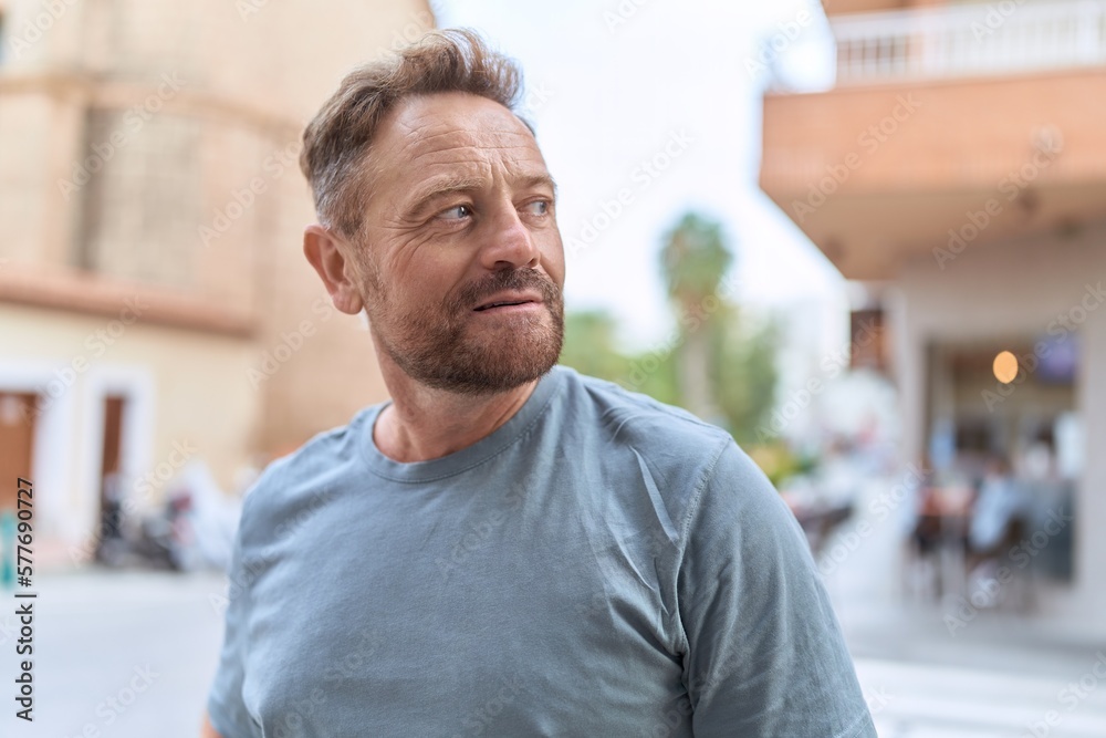 Middle age man looking to the side with serious expression at street