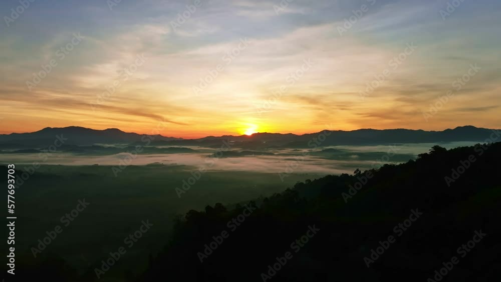 High angle view drone view of fog in rainy season over mountains,Beautiful sunrise sky clouds for create nature video scene. 4K High quality footage High angle view drone view of fog in rainy season over mountains,Beautiful sunrise sky clouds for create nature video scene. 4K High quality footage