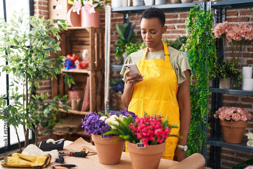 African american woman florist using smartphone at florist