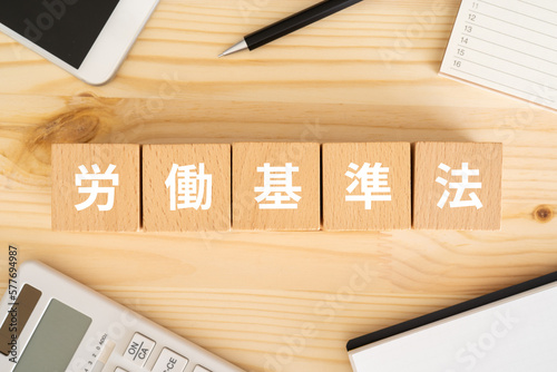Plakat 労働基準法と書かれたブロック、電卓、スマホ、カレンダー、ノート 