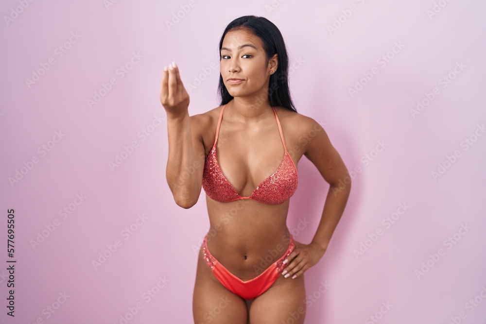 Hispanic woman wearing bikini doing italian gesture with hand and fingers confident expression Hispanic woman wearing bikini doing italian gesture with hand and fingers confident expression